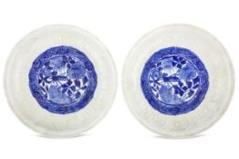 A PAIR OF CHINESE MOULDED BLUE AND WHITE DISHES. Ming Dynasty, Tianqi period. The central roundel
